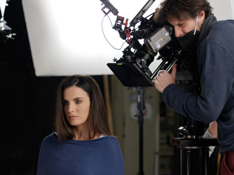 A professional cameraman taking a shot of a woman