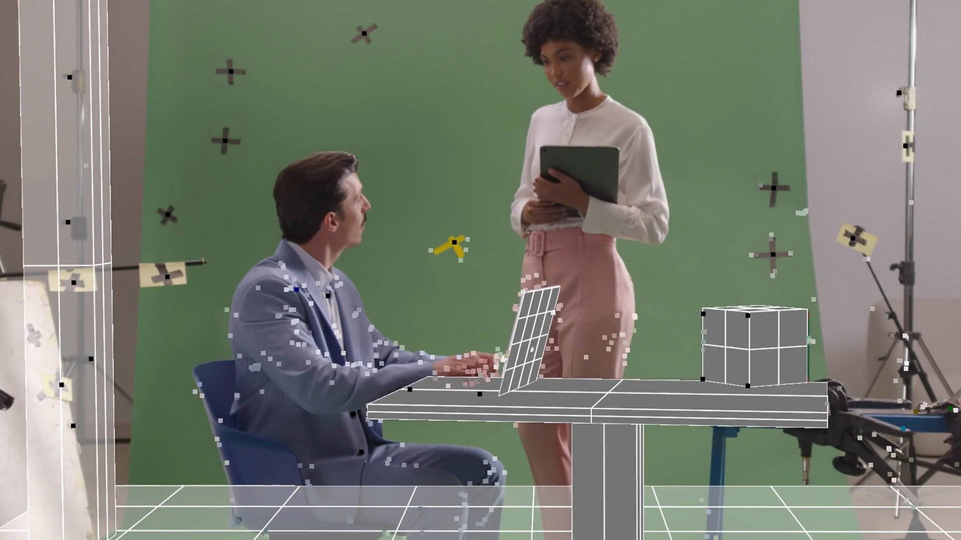 Behind the scenes of a two people in front of a green screen